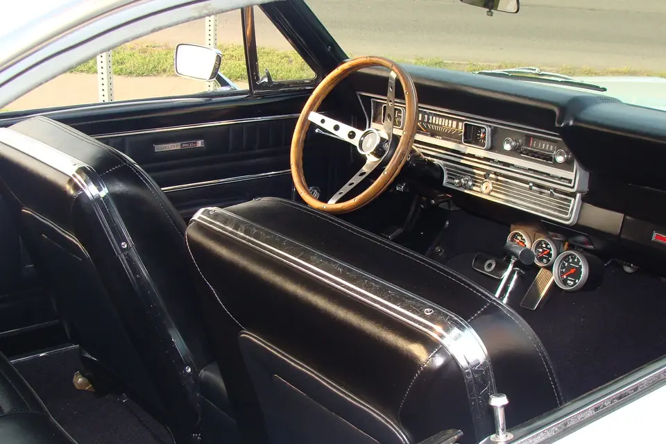 Classic car interior with vinyl seats and wood steering wheel