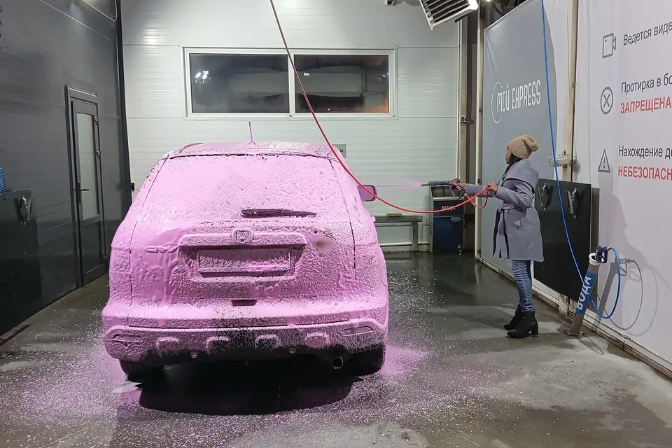 Foam-covered car in a self-service wash bay
