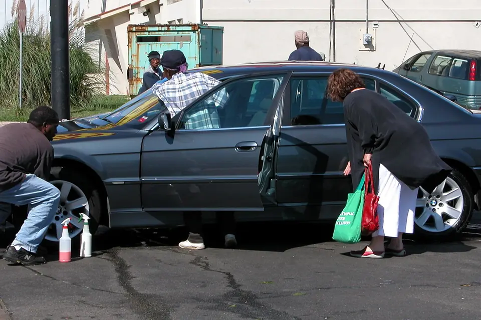 Owners cleaning a sedan at a self-service car wash