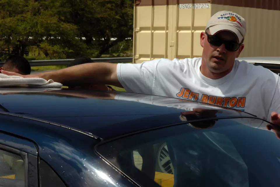 Wiping a freshly washed car dry with a towel